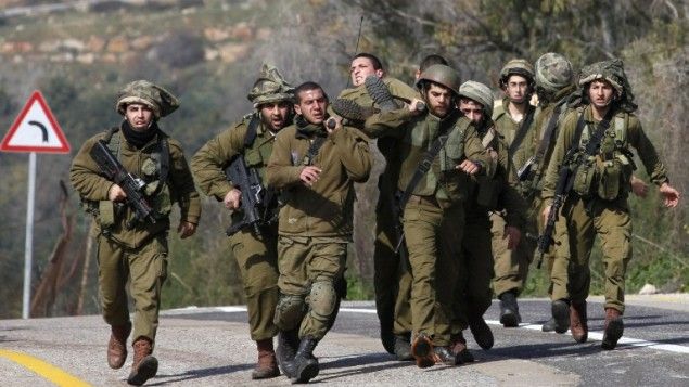 Israeli troops carry wounded